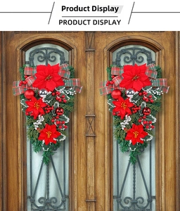 Detail of festive Christmas teardrop wreaths with red poinsettia and checkered bow on wood doors