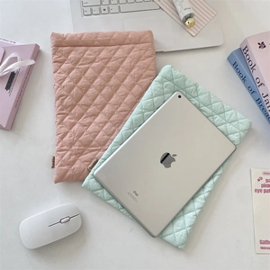 Quilted diamond laptop sleeve detail in pastel pink and mint green with woven label