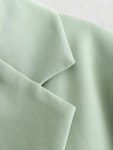 Close-up of mint green V-neck blazer collar showing high-quality twill fabric texture