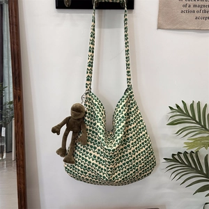 Detail of green floral cotton tote bag with adjustable strap and cute plush charm