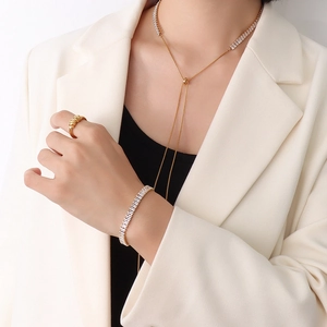 Set elegante con collana in titanio dorato e bracciale con zirconi indossato da modella