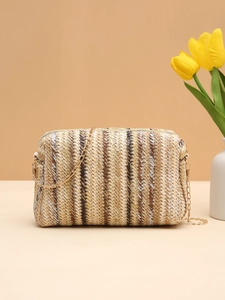 Detail of colorful woven straw camera bag with gold chain strap and striped pattern
