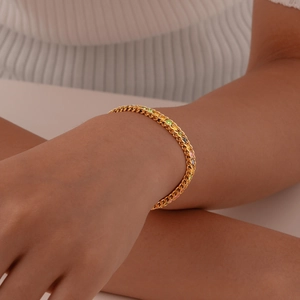 Close-up of golden Cuban link bracelet featuring vibrant rainbow gradient gemstones