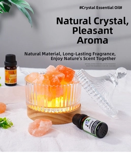 Glow from wooden base illuminating natural orange salt crystals in glass with oils