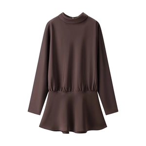 Détail d'une robe marron en satin à manches longues avec plis à la taille et volants