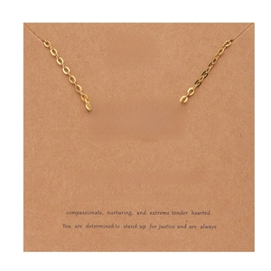 Detail of 18k gold Virgo zodiac necklace displayed on a kraft paper descriptive card