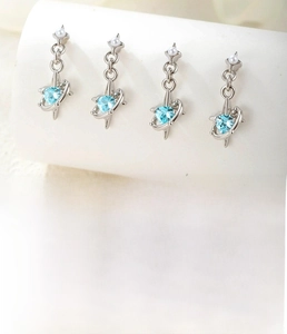 Detailed macro view of silver titanium steel star pendants with light blue zircon stones