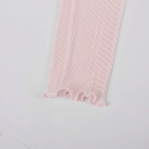 Detailed macro view of the light pink ribbed knit fabric with sweet lettuce edge hem