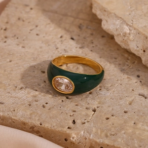 Detail of 18K gold plated ring with green enamel and oval cubic zirconia on stone