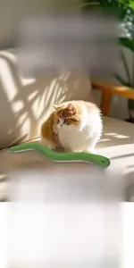 Detail of the soft green plush snake toy with red tongue showing rich fabric texture