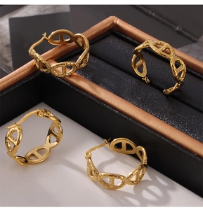 Macro detail of 18k gold plated stainless steel hollow anchor chain hoop earrings