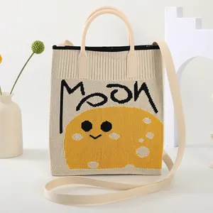 Chic beige knitted tote bag with MOON print, featuring top handles and a long shoulder strap