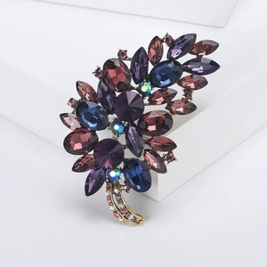 Close-up of vintage flower brooch with purple rhinestones and antique gold finish