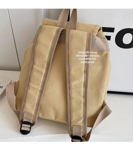 Detalle de la mochila de lona caqui con correas anchas ajustables y asa superior robusta