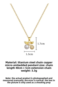 Close-up of gold cherry pendant with pearl and rhinestones on titanium steel chain