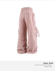 Dettaglio dei pantaloni cargo rosa con vita elastica, tasca posteriore e lacci laterali