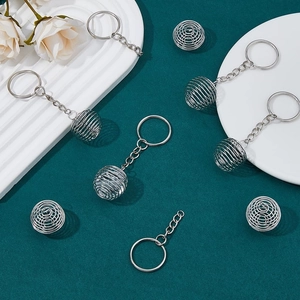 Silver stainless steel spiral cage pendant with key ring on a stylish display tray