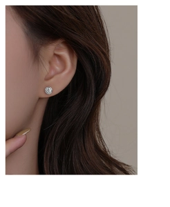 Macro view of sparkling zircon halo stud earrings on model in high-grade S999 sterling silver