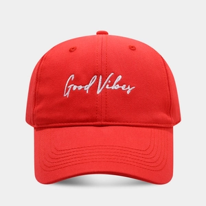 Detailed embroidery of Good Vibes on a vibrant red cotton baseball cap with curved brim
