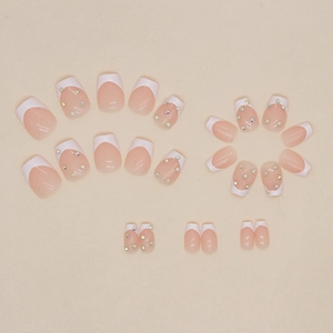 Short ballet press-on nails with white French tips and sparkling rhinestone accents
