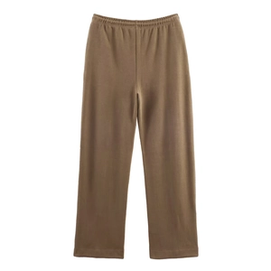 Detail of dark brown wide-leg trousers showing the elastic waistband and fabric texture