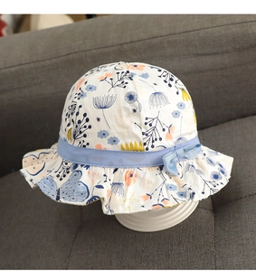 Detail of floral baby sun hat with light blue ribbon bow on cotton fabric material