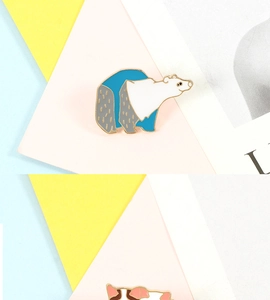 Detailed view of a stylized polar bear enamel pin badge with vibrant blue and white colors