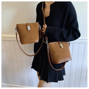 Detail view of retro brown suede bucket bags with leather trim and adjustable straps