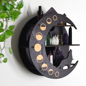 Detail of a crescent moon wooden shelf with wolf silhouette holding crystals and bottle