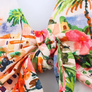 Détail macro du nœud à imprimé tropical avec motifs de palmiers et fleurs colorées