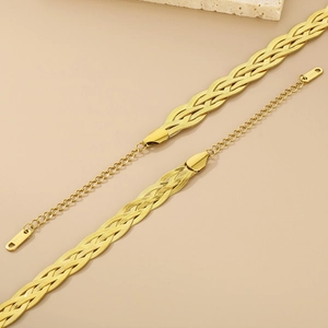 Detailed view of woven herringbone gold chain bracelets with lobster clasp and S.STEEL stamp