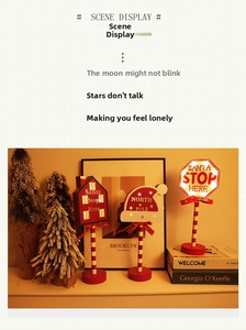 Macro view of Christmas LED decor featuring Santa Stop Here sign and wooden house details
