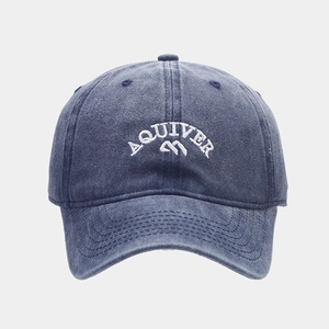 Detailed close-up of white AQUIVER embroidery on navy washed cotton baseball cap