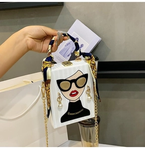 Detail of box clutch bag with female portrait print and silk scarf wrapped handle