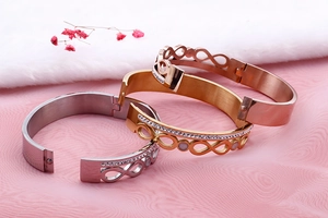 Detail of three-color infinity steel bracelets featuring double-row crystal pave setting