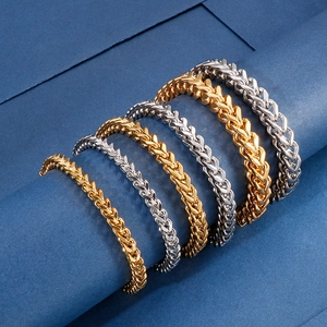 Detailed view of woven keel chains in gold and silver finish on a blue background