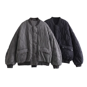 Close-up of quilted bomber jacket texture showing onion patterns and ribbed cuffs