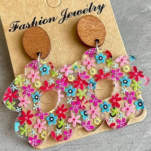 Floral acrylic earrings with round wooden studs displayed on jewelry card