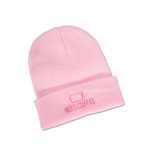 Detail of pink knitted beanie featuring NEED COFFEE embroidery and low battery icon
