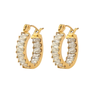 Detail of gold C-shaped hoop earrings featuring pave-set rectangular baguette zircons