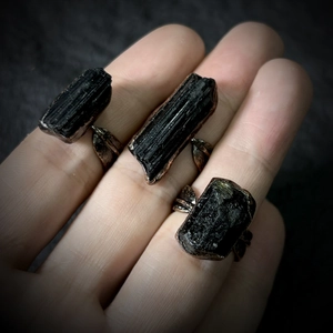 Detailed close-up of retro black tourmaline raw stone rings with antique bronze leaf design
