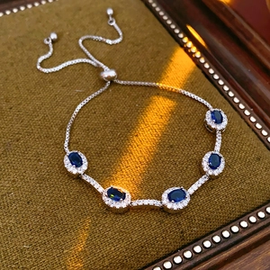 Detail eines verstellbaren Armbands mit ovalen blauen Zirkonen auf Samtbox