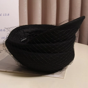 Detail of vintage black wool beret with delicate mesh veil and elegant French style design