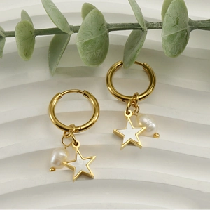 Détail des breloques étoile et perle dorées 18K sur boucles d'oreilles pendantes