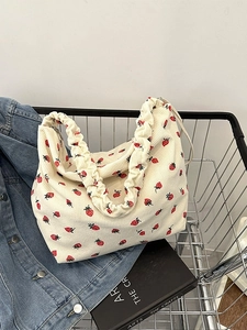 Chic corduroy tote bag with red strawberry print and ruffled strap in a shopping cart