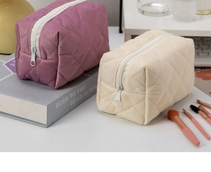 Detail of quilted corduroy cosmetic bags with silver zippers in dusty pink and cream