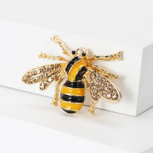 Detailed close-up of a bee brooch with yellow enamel and sparkling crystal wings