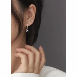 Close-up of butterfly earrings with sparkling white zircons on a model's ear