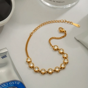 Détail du bracelet en acier doré avec zircons cubiques et fermoir mousqueton réglable
