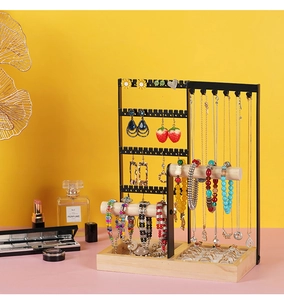 Detail view of double wooden rods and metal hooks for jewelry storage on a sturdy wood base